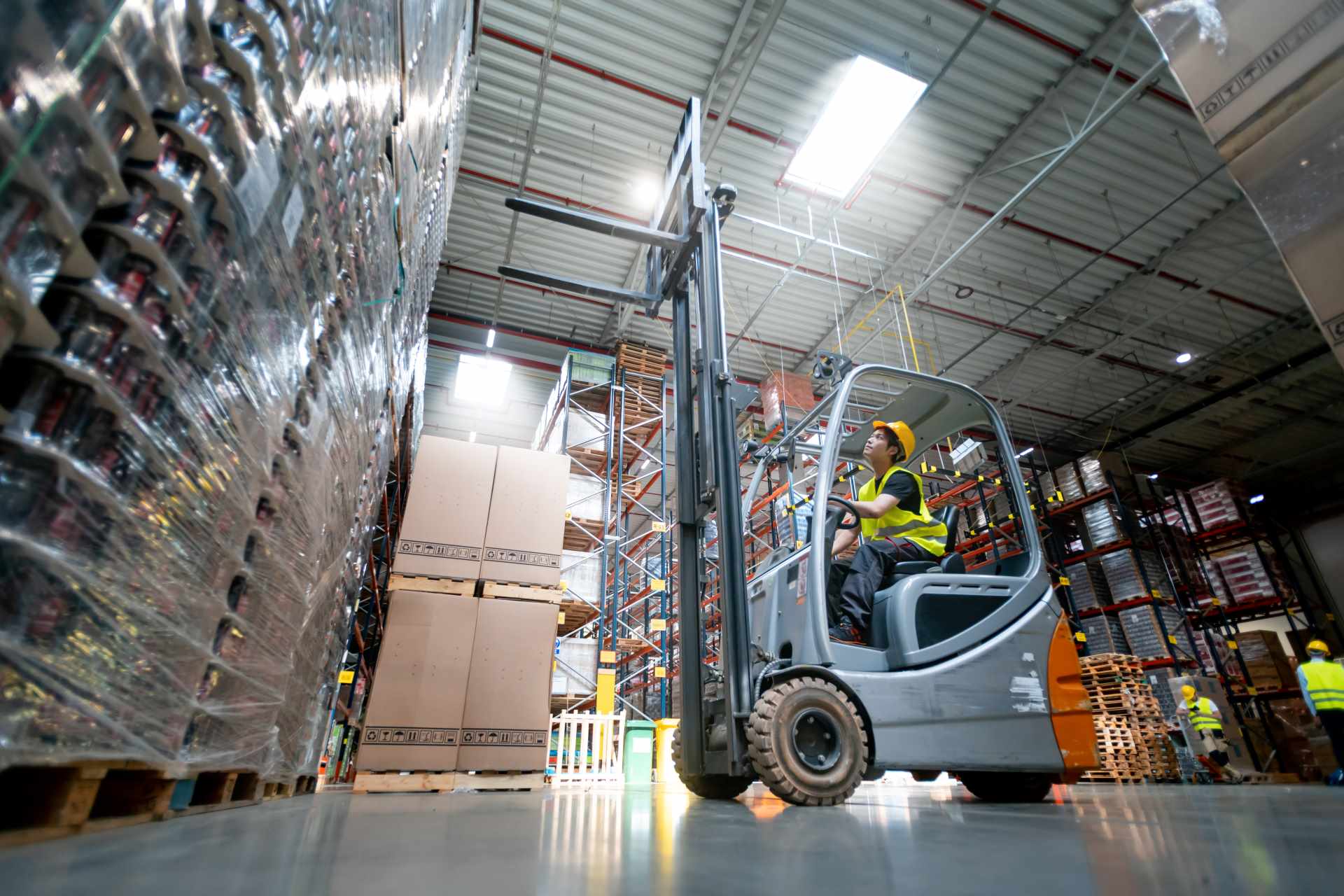 Warehouse worker operates a forklift | Featured image for General Forklift Safety Tips - Forklift Operation Safety Blog.